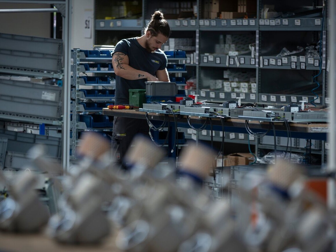 Immagine di un operaio Vismec al banco da lavoro per la produzione di sensori di livello per granuli plastici