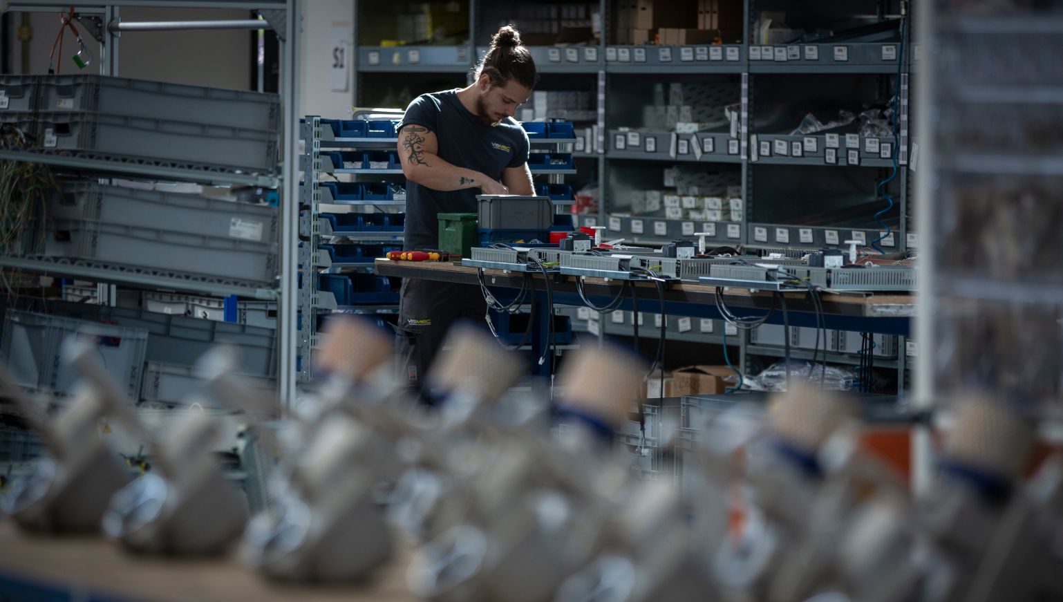 Immagine di un operaio Vismec al banco da lavoro per la produzione di sensori di livello per granuli plastici